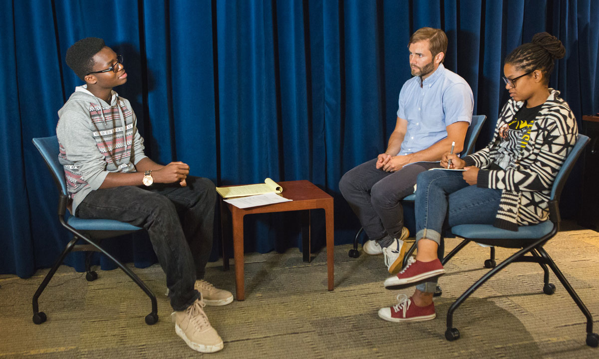 two students discussing with an instructor