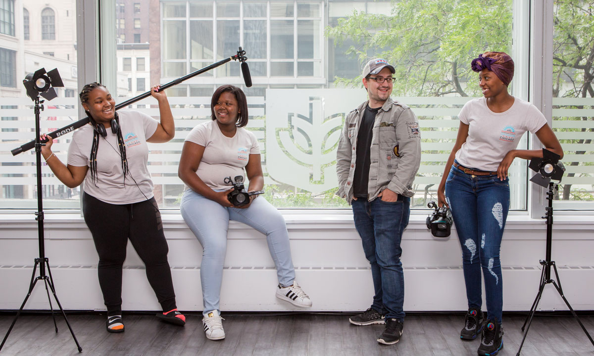 four students taking a break with camera equipment