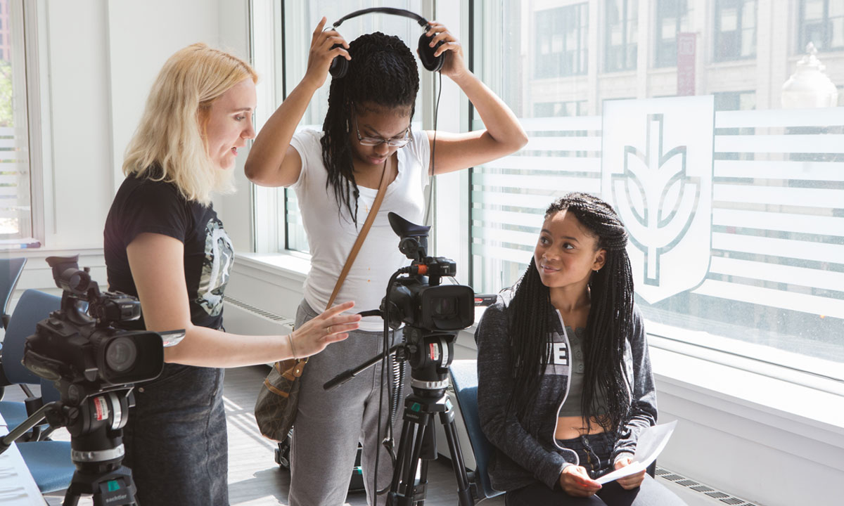 two female students with a film instructor