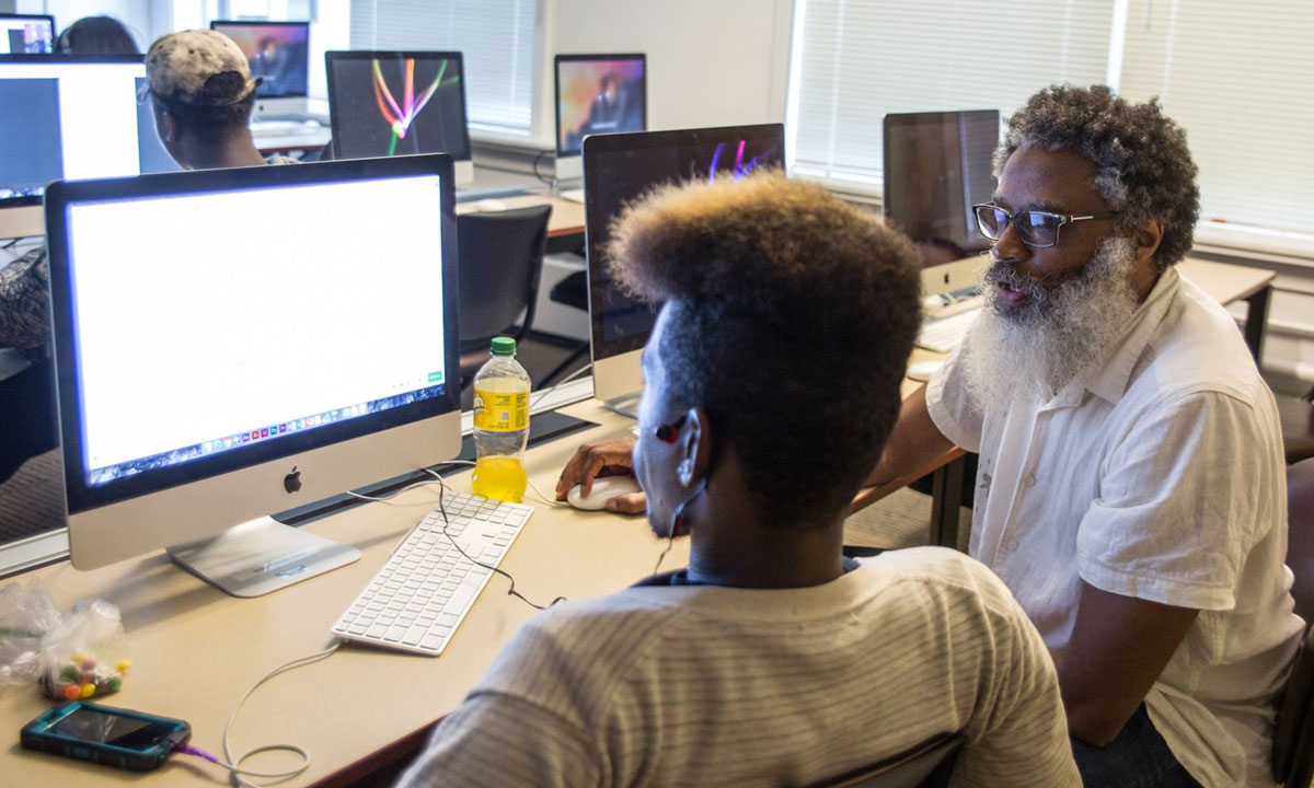 Instructor with student using a computer