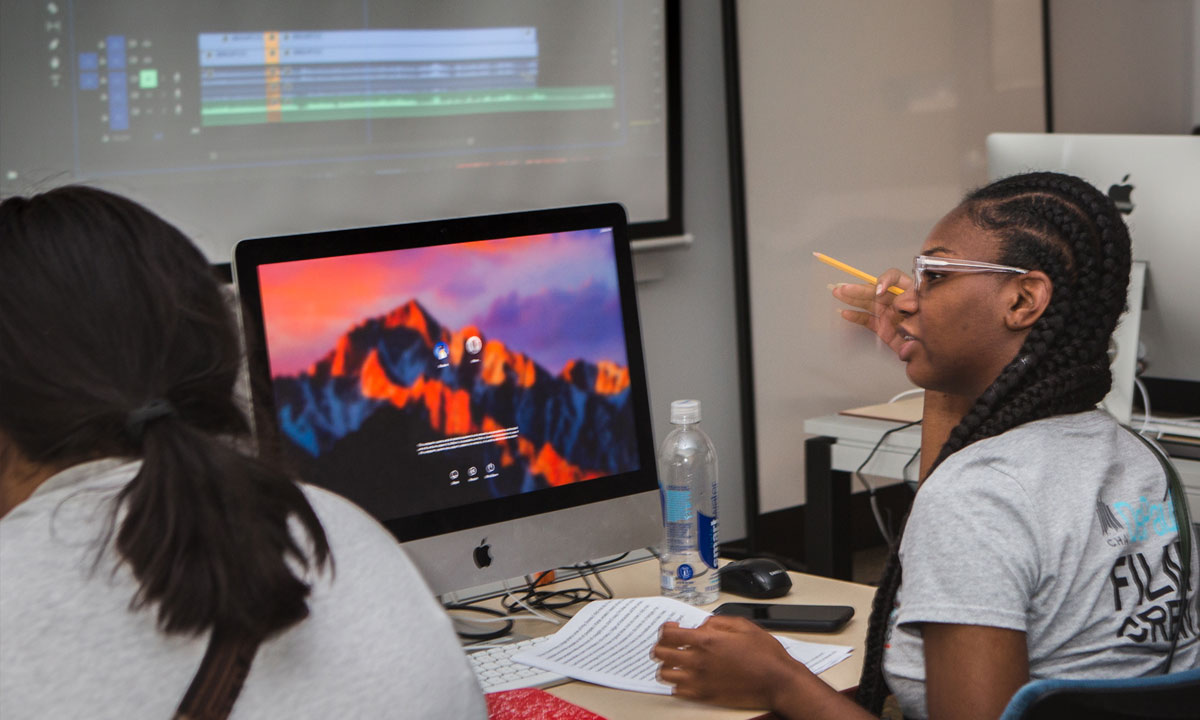 Two teens working on computers